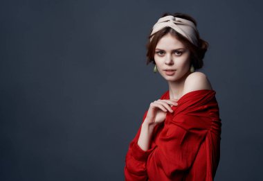 Kırmızı elbiseli güzel bir kadın ve saç bandı makyaj malzemesi.