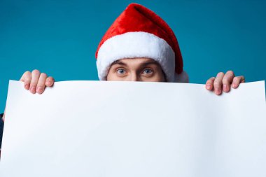 Noel Baba şapkalı neşeli adam izole edilmiş bir tatil geçmişi tutuyor.