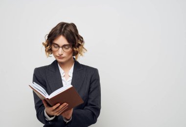 Elinde kitap olan iş kadını. Geçmişi aydınlık.