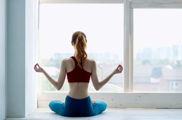 Pencere kenarında oturan kadın. Yoga egzersizinin zayıf şekli. — Stok fotoğraf