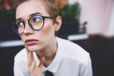 Kısa saçlı kadın sokakta elinde bir kitapla hayat tarzını anlatıyor.