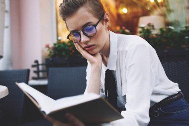 Sokakta elinde kitapla gezen bir kadın.