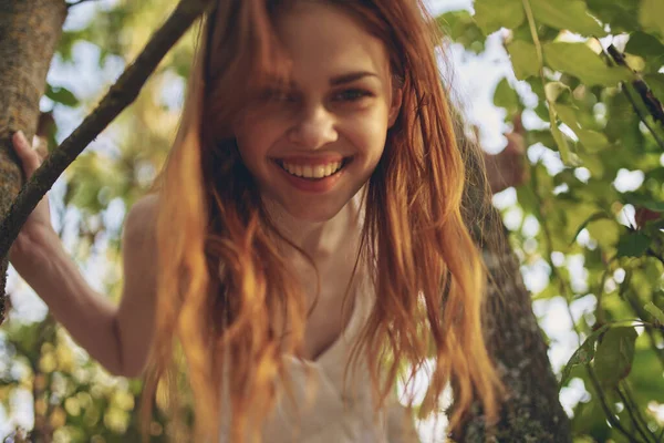 木のポーズの近くの森の中の赤い髪の女性 高品質の写真 — ストック写真