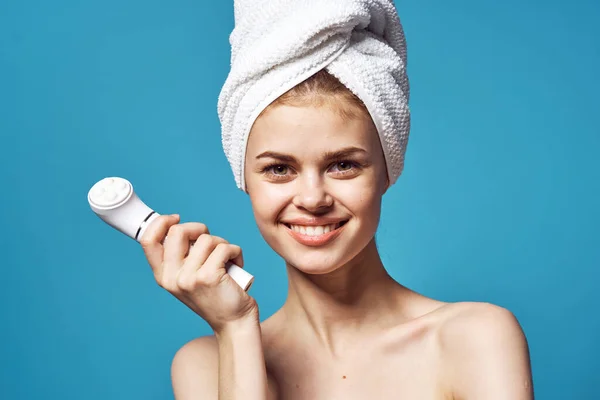 Schöne Frau mit einem Handtuch auf dem Kopf Massagegerät in Hände Hautpflege — Stockfoto