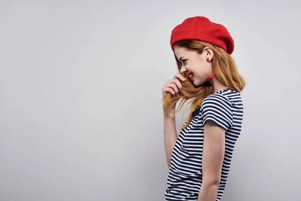 Jolie femme dans un t-shirt rayé rouge à lèvres geste avec ses mains fond clair — Photo