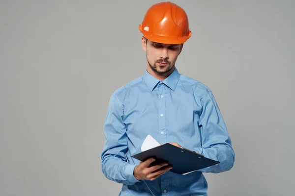 Man in orange helmet blueprints builder isolated background — Stock Photo, Image