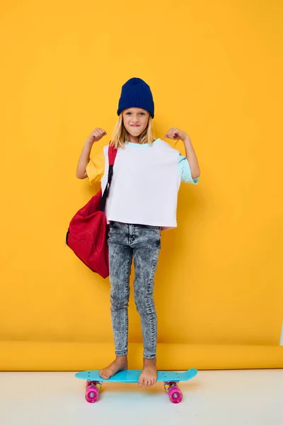 スケートボードを手にした白いTシャツを着た可愛い女の子の写真子供のライフスタイルのコンセプト — ストック写真