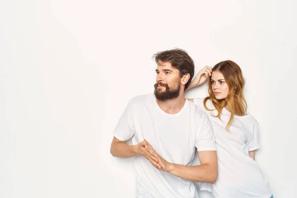 Uomo e donna in t-shirt bianche sono in piedi accanto a sfondo luce familiare — Foto Stock