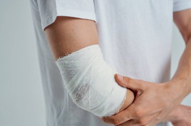 İzole edilmiş arka planda elleri bandajlı hasta bir adam. Yüksek kalite fotoğraf