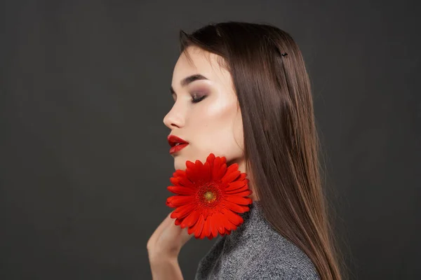 Όμορφη Γυναίκα Φωτεινό Μακιγιάζ Κρατώντας Κόκκινο Λουλούδι Κοντά Στο Πρόσωπο — Φωτογραφία Αρχείου
