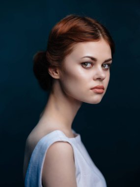 Stüdyoda poz veren beyaz elbiseli çekici kadın. 