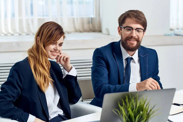man and woman managers work together in front of laptop professionals technology