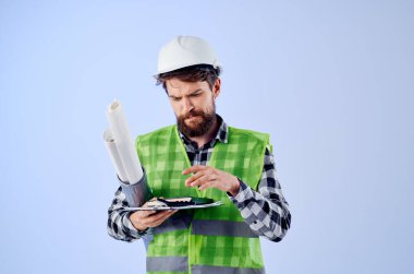 Beyaz kask planlarında mühendis. Profesyonel mavi arka plan.