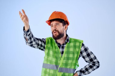 Üniformalı sakallı bir adam inşaat işiyle uğraşıyor.