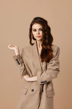 Bej arka planda elleri olan çekici kadın mankeni ceketi Kopyalama Boşluğu