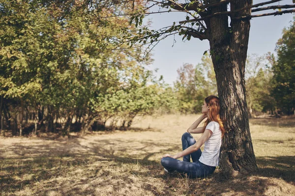 Mujer sentada cerca de un árbol Viaje por la libertad del sol —  Fotos de Stock