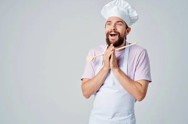 Um chef com uma colher de madeira nas mãos de um serviço de restaurante profissional — Fotografia de Stock