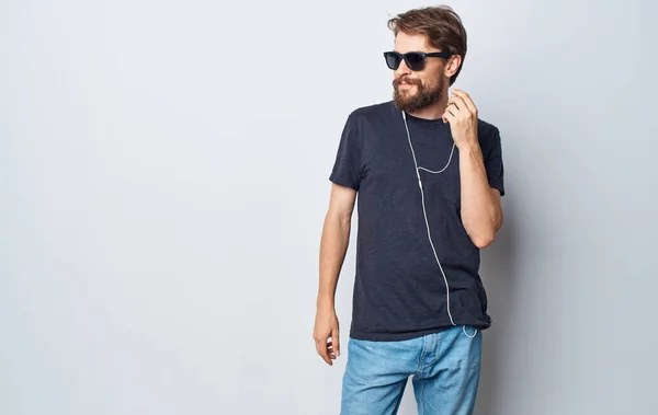 Γενειοφόρος άνδρας που φοράει γυαλιά ακούγοντας μουσική στον τρόπο ζωής των ακουστικών — Φωτογραφία Αρχείου