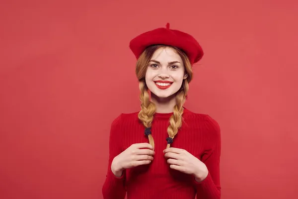 빨간 스웨터를 입고 빨간 배경을 가진 예쁜 여자 — 스톡 사진