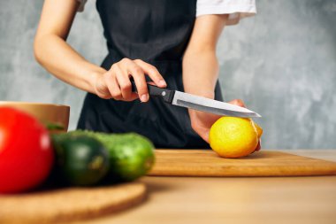 Ev hanımı mutfakta sebze doğruyor.