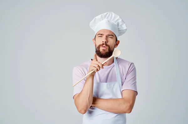Chef com colher de madeira na mão trabalhando cozinha profissional — Fotografia de Stock