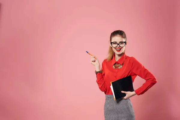 Femme en chemise rouge portant des lunettes bloc-notes dans les mains de travail professionnel — Photo