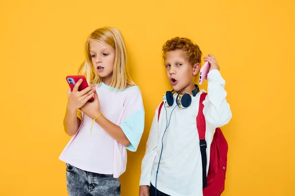 Dos niños niño y niña usan gadgets con auriculares concierto de adicción de niños y gadgets —  Fotos de Stock