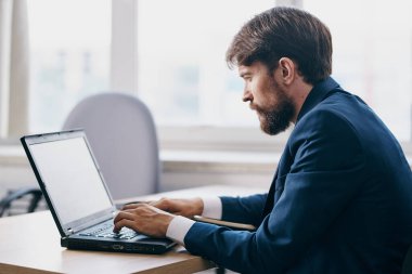 Ofisteki işadamları profesyonel bir dizüstü bilgisayarın önünde.