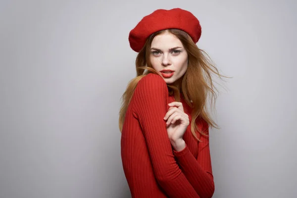 머리에 붉은 모자를 쓴 예쁜 여자가 밝은 배경을 가지고 있다 — 스톡 사진