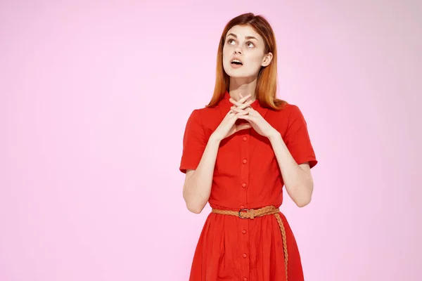 穿着红裙的女人或穿着时髦工作室粉色背景的女人 — 图库照片