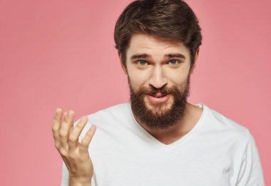 Beyaz tişörtlü sakallı adam öfke stüdyolarını işaret ediyor.