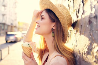 Çekici bir kadın açık havada yürüyor dondurma yiyor seyahat mankeni yiyor.