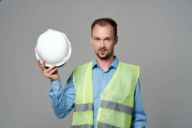 Beyaz kask mühendisi, güvenlik ışığı arka planında çalışan.