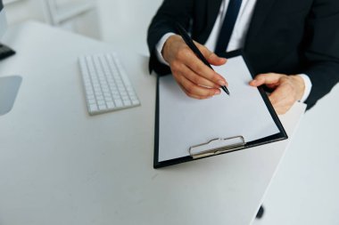 Erkek müdürün belgeleri telefon şefiyle el iletişimi halinde.