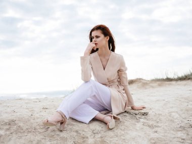 Kum modelinde oturan güzel kadın Seyahat et