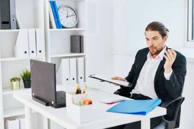 İşadamları bürosu, ellerinde telefon olan evrakları inceliyor.