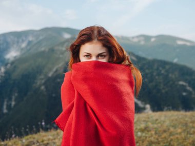 Dışarıdaki kırmızı ekose elbiseli kadın serin hava veriyor.