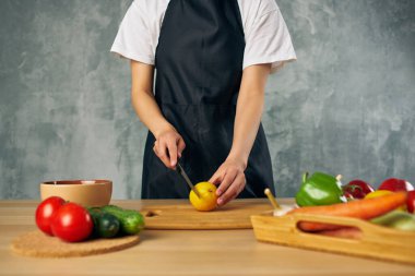 Siyah önlüklü kadın evde vejetaryen salata diyeti yapıyor.