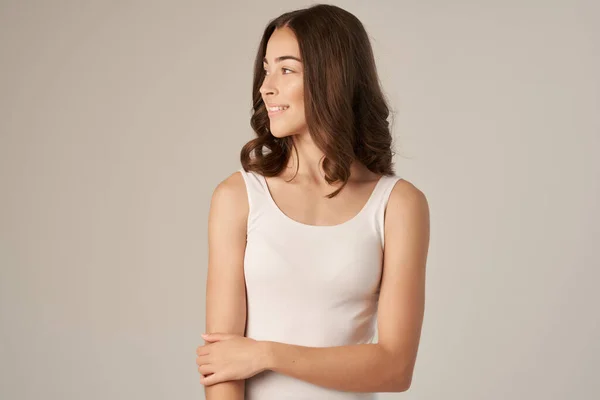 Bella donna in una t-shirt bianca cura dei capelli isolato sfondo — Foto Stock