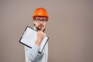 Sakallı adam elinde belgelerle koruyucu üniforma çiziyor.