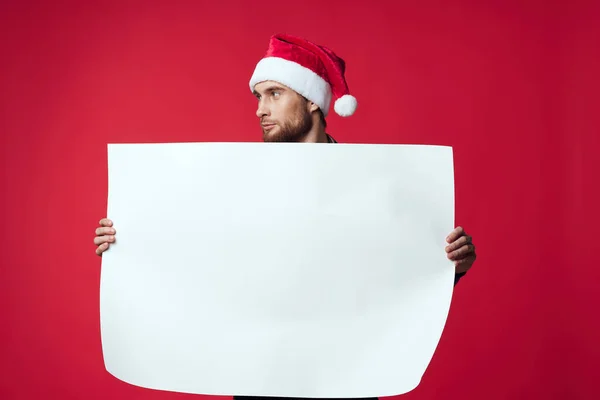 Hombre alegre en una maqueta blanca de navidad póster fondo rojo — Foto de Stock