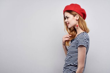 Güzel bir kadın moda pozu veriyor. Kırmızı küpeler takı ışığı arka planı.