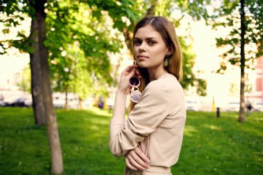 Bu yaz şehir gezisinde güzel bir kadın parkta yürüyor.