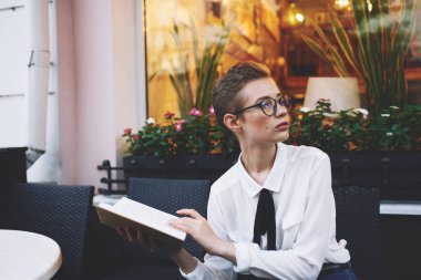 Öğrenci dışarıda bir kafede dinleniyor.