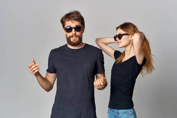 fashionable man and woman in black t-shirt sunglasses posing isolated background