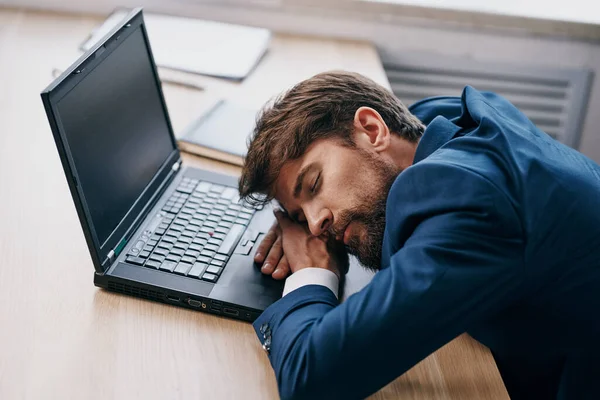 Homem de negócios cansado na frente do laptop no escritório — Fotografia de Stock