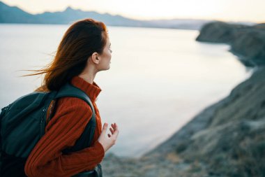 Kadın turist sırt çantası dağlar okyanus manzarası