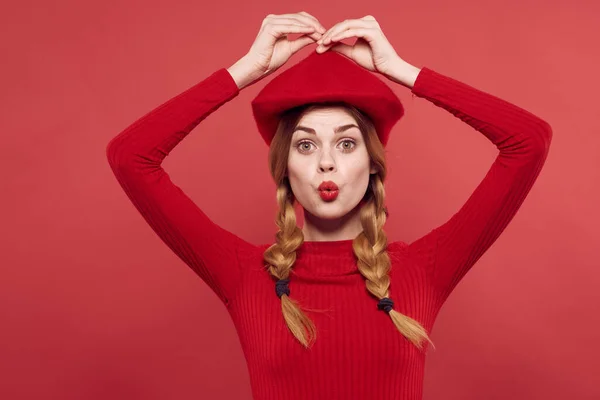 Bela mulher em um suéter vermelho cosméticos emoção vermelho fundo — Fotografia de Stock