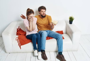 Genç bir çift kanepede oturup film izleyecek.