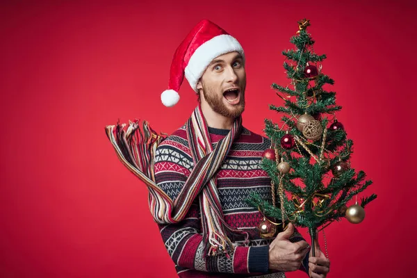 Süveterli bir adam Noel ağacı oyuncakları süslemesi — Stok fotoğraf